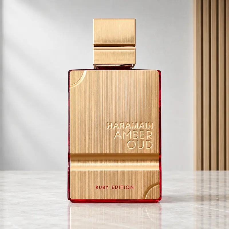 Al Haramain Amber Oud Ruby Edition bottle shown front-on with brushed-gold panel and ruby-red glass.