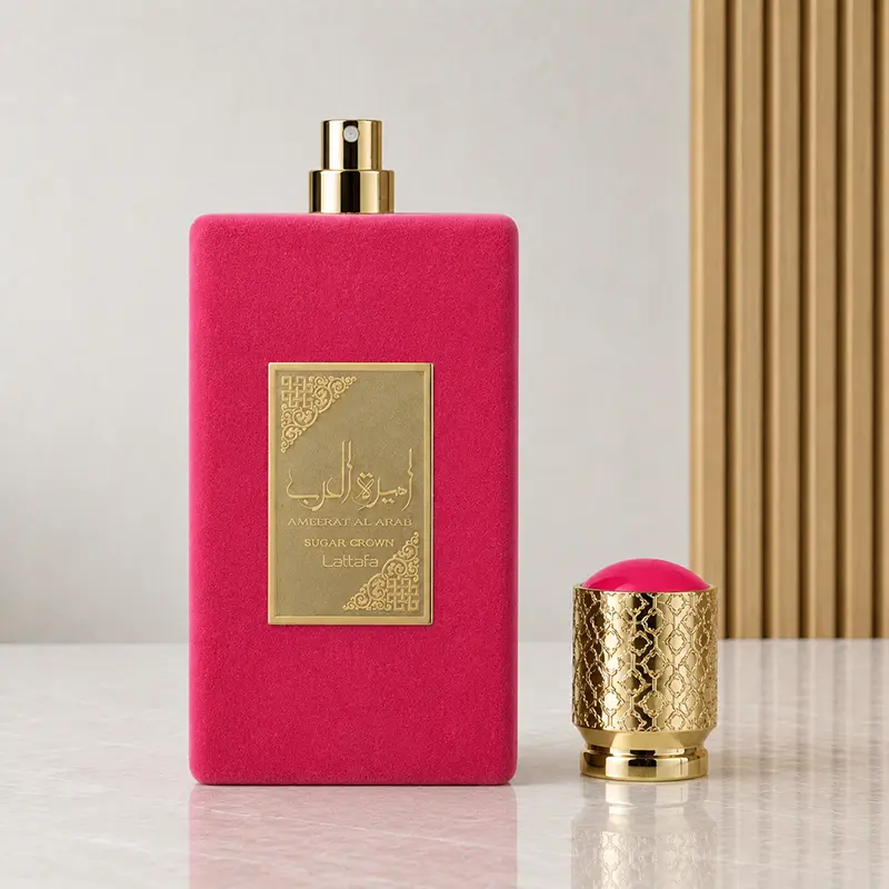 An exposed gold-coloured atomiser tops the pink Sugar Crown bottle, with its patterned cap standing beside it.