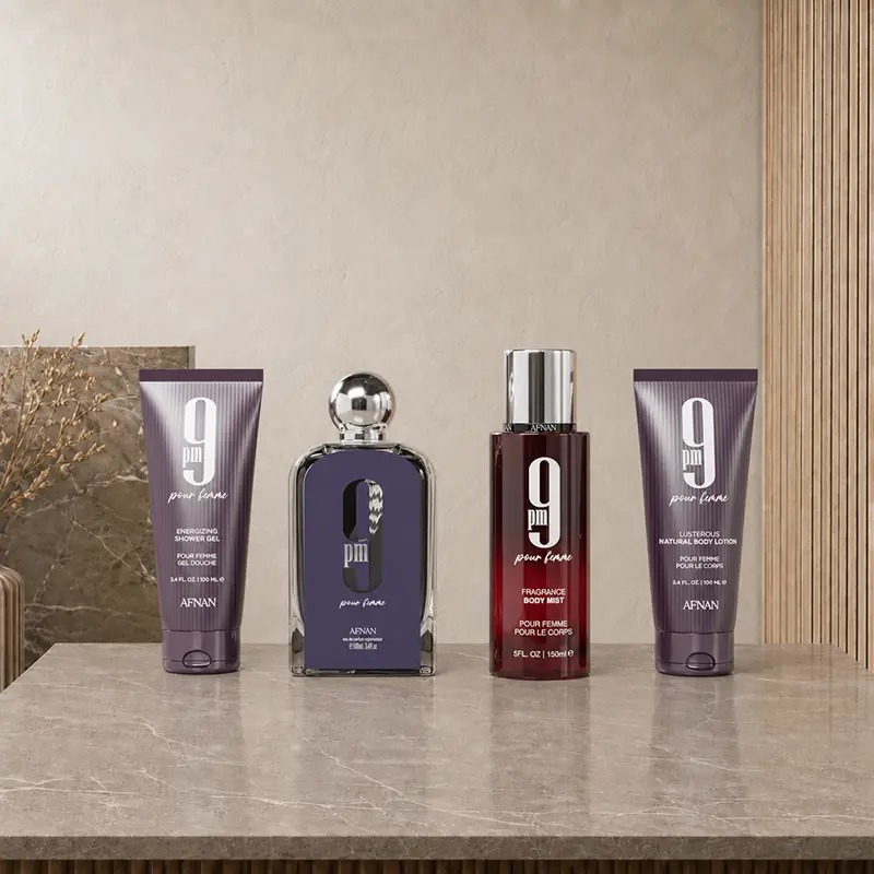 Four Afnan 9 PM Pour Femme products arranged together on a stone surface.