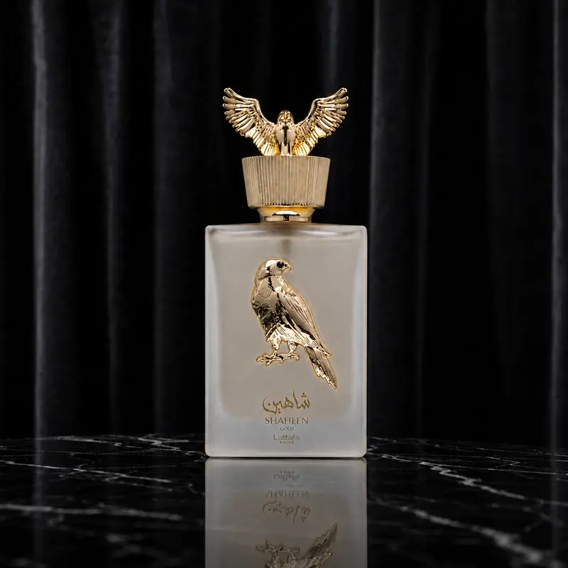 Shaheen Gold perfume bottle on black marble with dark curtain background