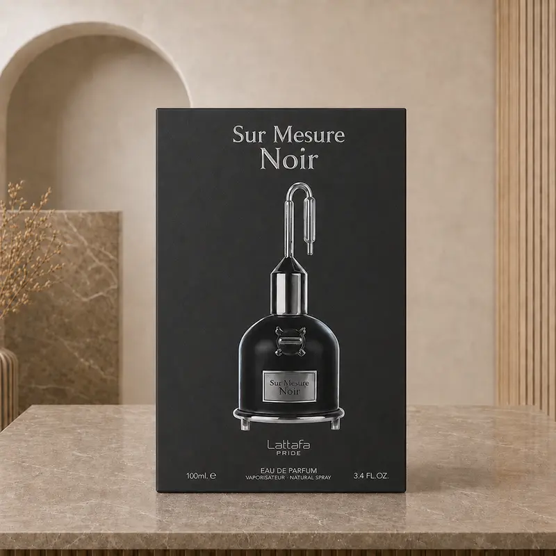 Black Sur Mesure Noir presentation box centered on a marble tabletop in a beige setting.