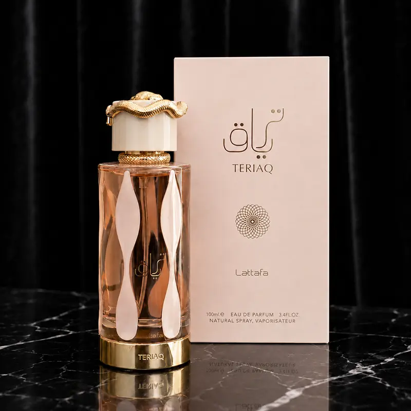 Teriaq bottle beside its front-facing box on black marble with dark velvet backdrop