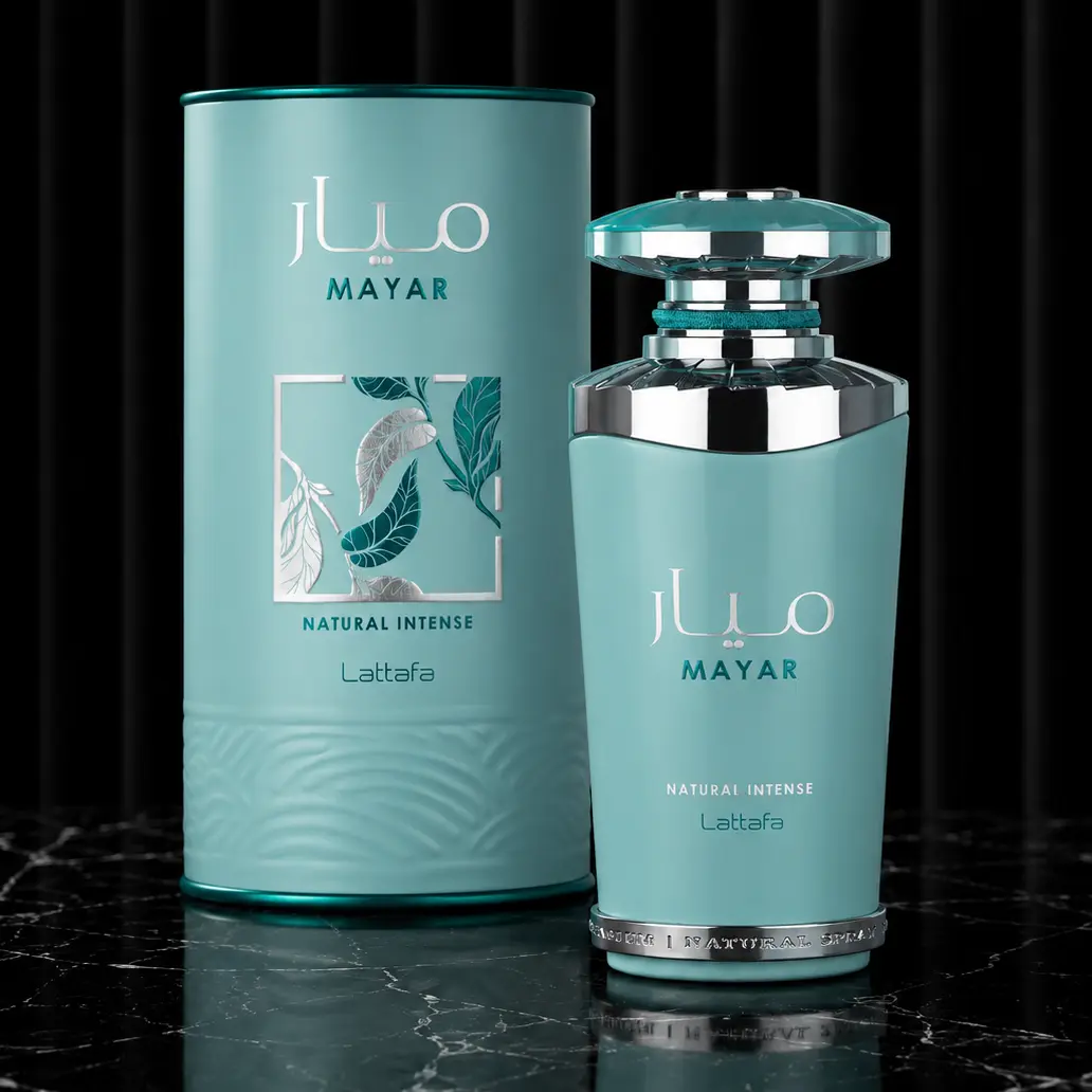 Cylindrical Mayar Natural Intense box and matching turquoise bottle on a glossy black surface