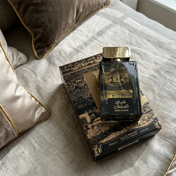 Lifestyle mood presentation of Lattafa Qasaed Al Sultan resting on elegant fabric reflecting luxury positioning.