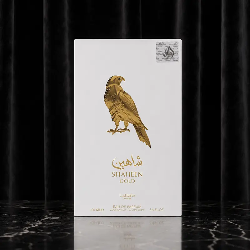 White Shaheen Gold perfume box with gold falcon artwork on black marble